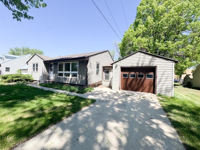 view of front facade featuring asphalt driveway, an outbuilding, a detached garage, a front yard, and entry steps