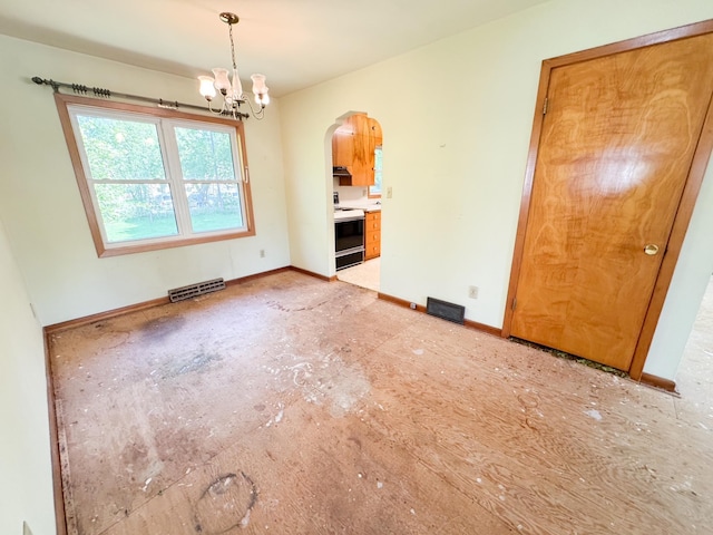 empty room featuring arched walkways, a chandelier, and baseboards