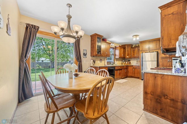 1214 8th St N, Moorhead, MN 56560 - dining space with a chandelier, healthy amount of natural light, light tile patterned floors, and baseboards