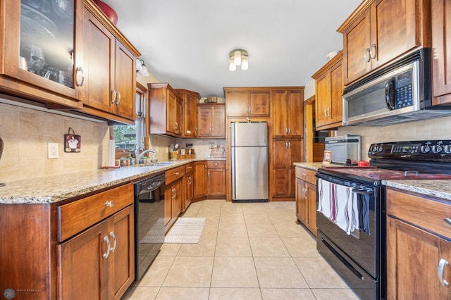 1214 8th St N, Moorhead, MN 56560 - kitchen featuring black appliances, light tile patterned flooring, brown cabinetry, and a sink