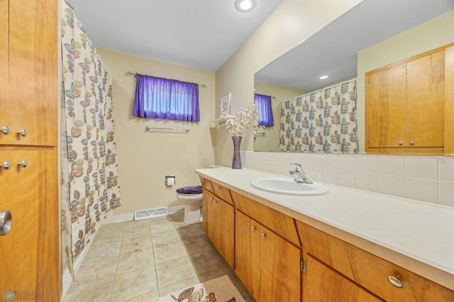 1214 8th St N, Moorhead, MN 56560 - bathroom with vanity, toilet, a shower with shower curtain, and baseboards