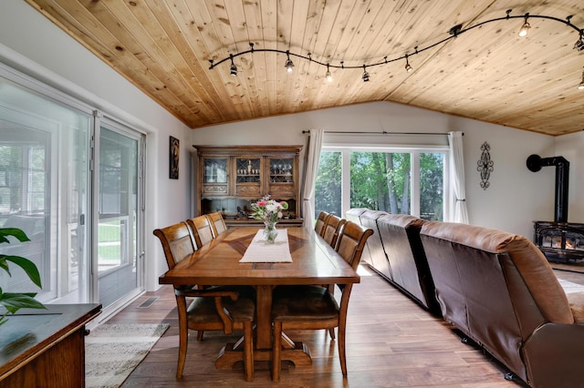 7256 Maciver Ave NE, Otsego, MN 55301 - dining room featuring rail lighting, vaulted ceiling, a wood stove, wooden ceiling, and light wood-type flooring