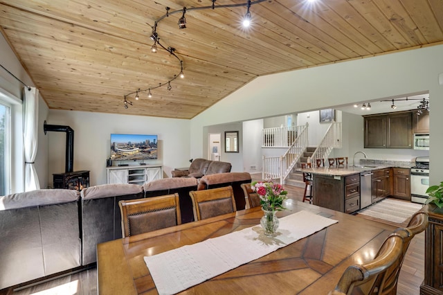 7256 Maciver Ave NE, Otsego, MN 55301 - dining area with track lighting, wood ceiling, lofted ceiling, a wood stove, and stairs