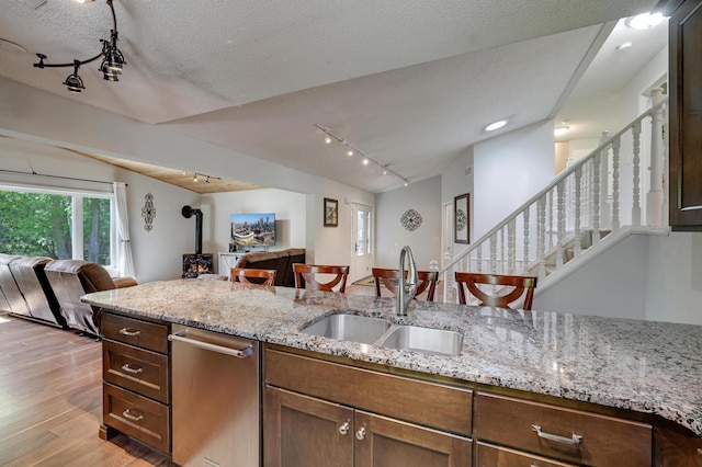 7256 Maciver Ave NE, Otsego, MN 55301 - kitchen featuring rail lighting, a sink, open floor plan, light wood-style flooring, and a wood stove