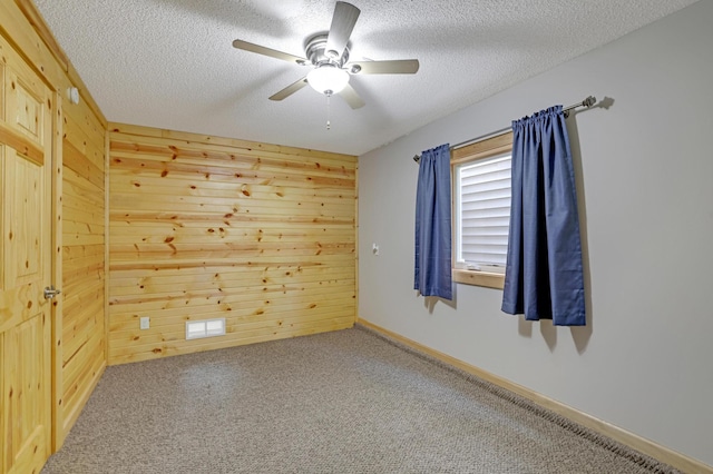 7256 Maciver Ave NE, Otsego, MN 55301 - carpeted empty room featuring wood walls, a textured ceiling, and ceiling fan