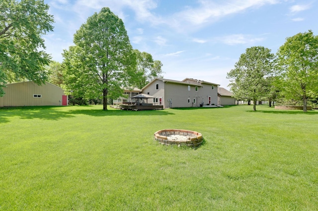 7256 Maciver Ave NE, Otsego, MN 55301 - view of grassy yard featuring an outdoor fire pit and a wooden deck