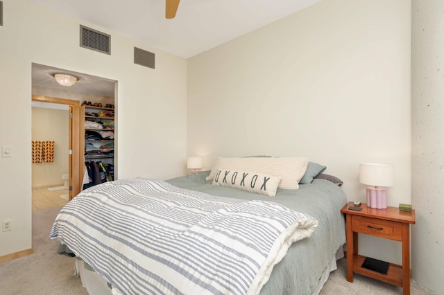 carpeted bedroom with a spacious closet, a closet, and ceiling fan
