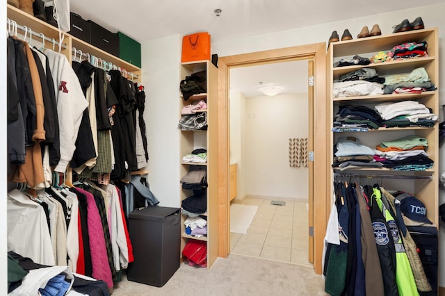 walk in closet with tile patterned floors and carpet flooring