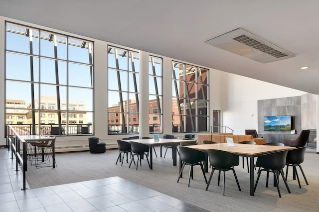 dining space with carpet, plenty of natural light, tile patterned flooring, recessed lighting, and a high ceiling