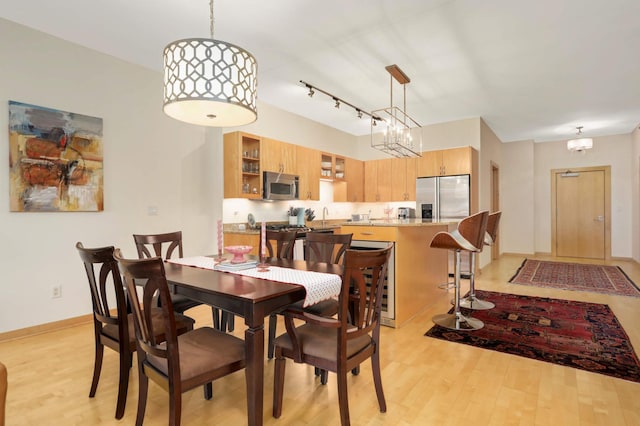 dining room with light wood finished floors and a chandelier