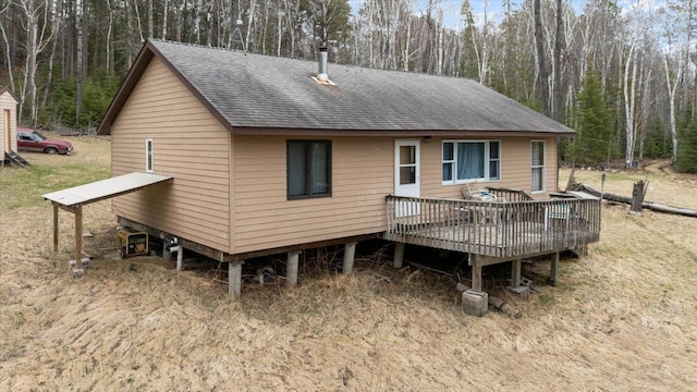 6301 Hunters Pass, Greenwood Twp, MN 55790 - rear view of property with roof with shingles, a wooden deck, and a wooded view