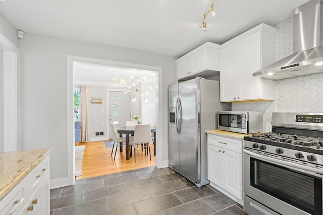 1354 Judith Ave, Roseville, MN 55113 - kitchen featuring stainless steel appliances, wall chimney exhaust hood, tasteful backsplash, white cabinets, and a chandelier