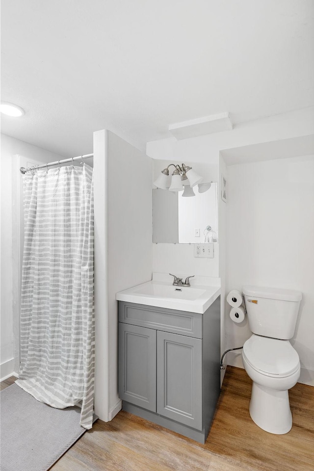1354 Judith Ave, Roseville, MN 55113 - full bathroom featuring wood finished floors, toilet, curtained shower, vanity, and baseboards