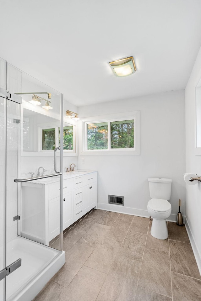 1354 Judith Ave, Roseville, MN 55113 - full bathroom featuring a stall shower, vanity, toilet, baseboards, and tile patterned flooring
