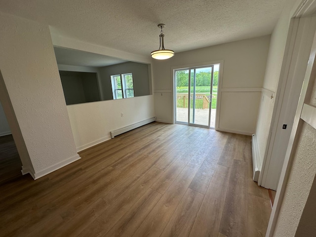 46130 Anchor Ave, Fish Lake Twp, MN 55080 - unfurnished room with a baseboard heating unit, a textured ceiling, wood finished floors, baseboards, and a textured wall