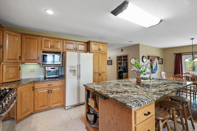15777 Grover Ave NW, Clearwater Twp, MN 55320 - kitchen with stainless steel appliances, a breakfast bar area, light wood finished floors, a center island, and brown cabinetry
