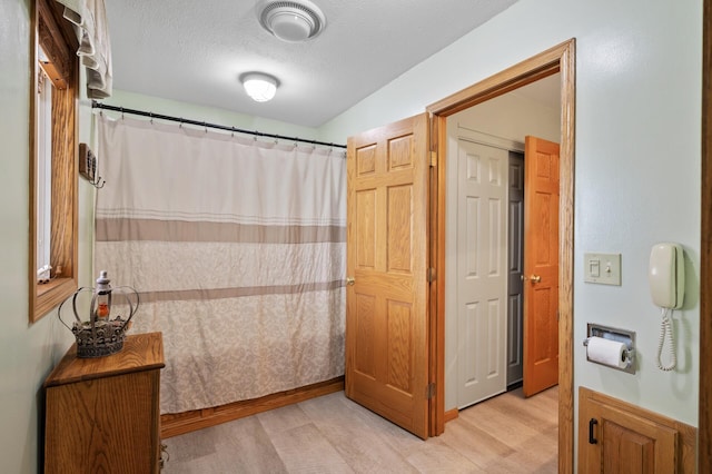 15777 Grover Ave NW, Clearwater Twp, MN 55320 - bathroom featuring wood finished floors, curtained shower, and a textured ceiling