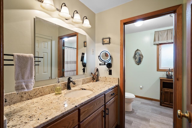 15777 Grover Ave NW, Clearwater Twp, MN 55320 - bathroom with toilet, vanity, baseboards, and wood finished floors