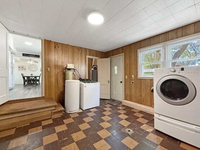 213 1st Ave E, Truman, MN 56088 - laundry room with dark floors, wood walls, washing machine and clothes dryer, and baseboards