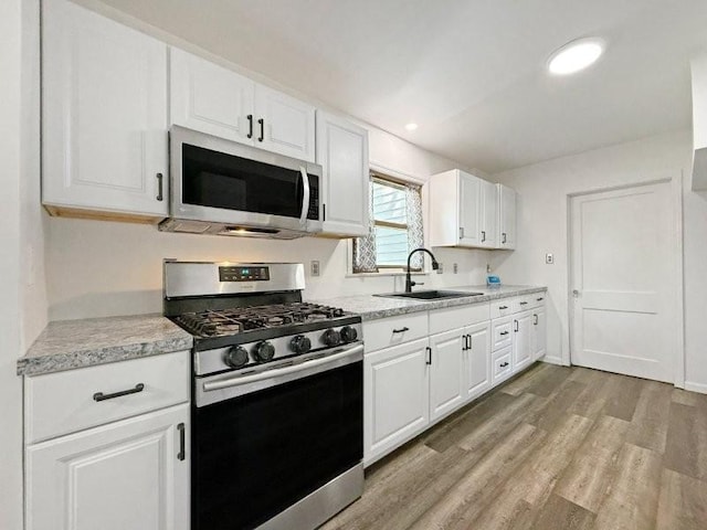 213 1st Ave E, Truman, MN 56088 - kitchen featuring stainless steel appliances, a sink, light countertops, light wood-style floors, and recessed lighting
