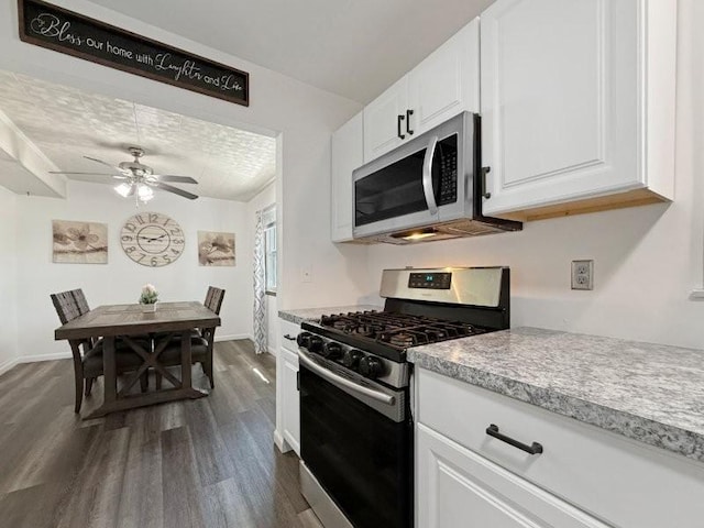 213 1st Ave E, Truman, MN 56088 - kitchen featuring stainless steel appliances, dark wood finished floors, light countertops, white cabinets, and a ceiling fan