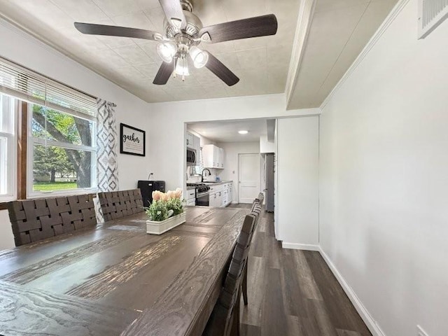 213 1st Ave E, Truman, MN 56088 - dining area featuring dark wood-type flooring, a ceiling fan, baseboards, and ornamental molding