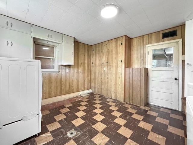 213 1st Ave E, Truman, MN 56088 - unfurnished room with wood walls, dark floors, and washer / dryer