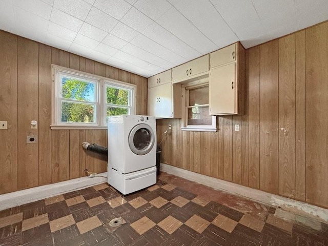 213 1st Ave E, Truman, MN 56088 - laundry room featuring dark floors, wooden walls, washer / dryer, and baseboards