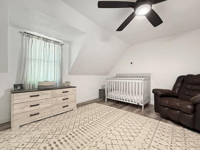 213 1st Ave E, Truman, MN 56088 - bedroom with wood finished floors, a crib, baseboards, lofted ceiling, and ceiling fan
