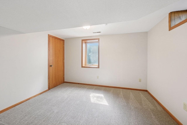 unfurnished room featuring light carpet and baseboards