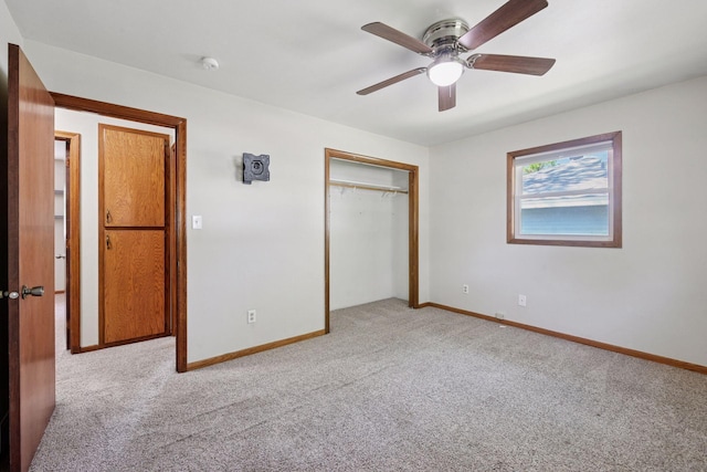 unfurnished bedroom featuring carpet floors, a closet, baseboards, and ceiling fan