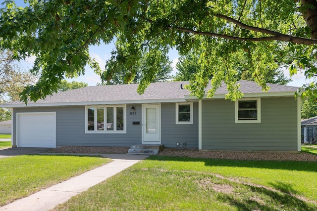 ranch-style house with a front lawn, asphalt driveway, and an attached garage