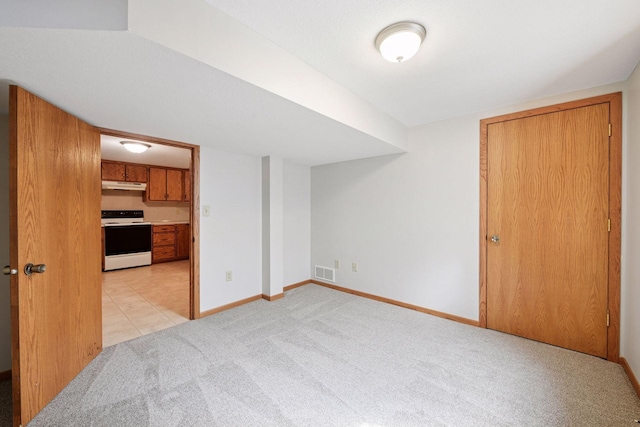 unfurnished living room featuring light colored carpet and baseboards