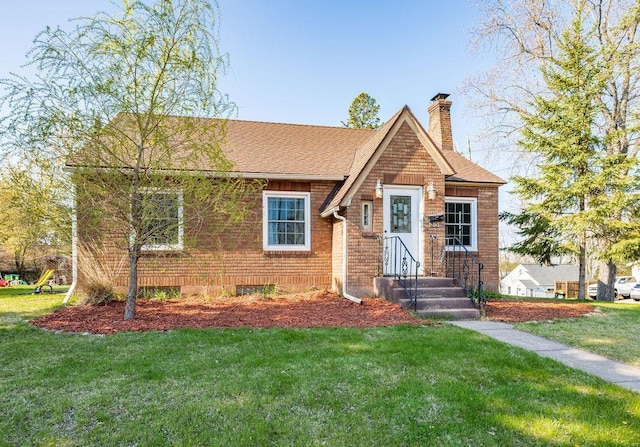 1815 Carlton Ave, Cloquet, MN 55720 - view of front of house featuring a chimney, a front yard, a shingled roof, and brick siding
