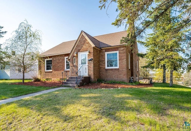 1815 Carlton Ave, Cloquet, MN 55720 - view of front of home with brick siding, a front yard, and a shingled roof