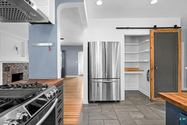1815 Carlton Ave, Cloquet, MN 55720 - kitchen featuring appliances with stainless steel finishes, wood counters, range hood, baseboards, and recessed lighting