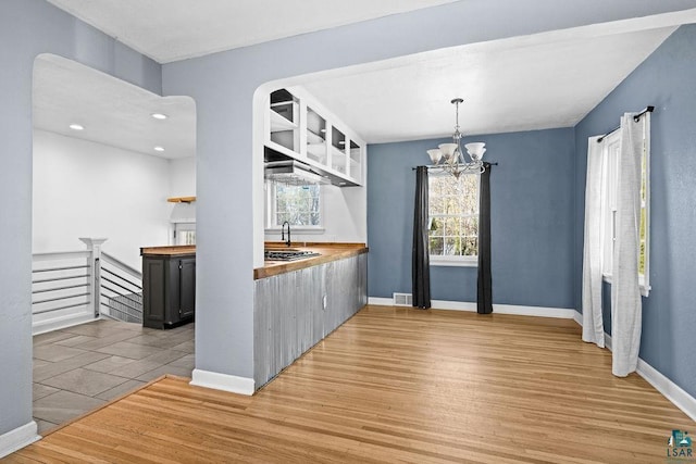 1815 Carlton Ave, Cloquet, MN 55720 - kitchen with light wood-style floors, open shelves, wooden counters, a chandelier, and baseboards