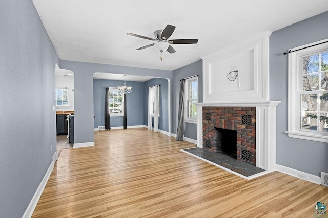 1815 Carlton Ave, Cloquet, MN 55720 - unfurnished living room with light wood-type flooring, a fireplace, a chandelier, and baseboards
