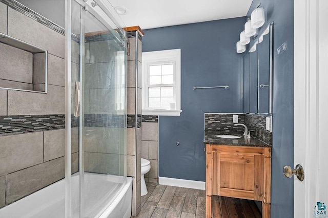 1815 Carlton Ave, Cloquet, MN 55720 - bathroom with wood finished floors, toilet, baseboards, enclosed tub / shower combo, and vanity