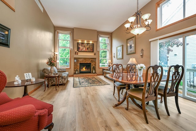2917 85th St E, Inver Grove Heights, MN 55076 - dining room with wood finished floors, a warm lit fireplace, a chandelier, and high vaulted ceiling