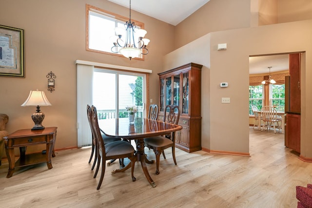 2917 85th St E, Inver Grove Heights, MN 55076 - dining area featuring a chandelier, light wood-type flooring, baseboards, and a towering ceiling