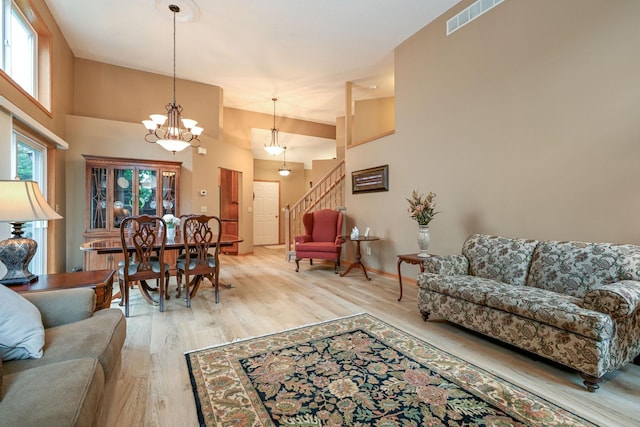 2917 85th St E, Inver Grove Heights, MN 55076 - living room with stairway, a chandelier, light wood finished floors, a high ceiling, and baseboards