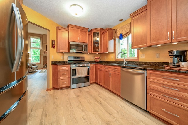 2917 85th St E, Inver Grove Heights, MN 55076 - kitchen featuring stainless steel appliances, light wood-style floors, a sink, brown cabinetry, and a textured ceiling