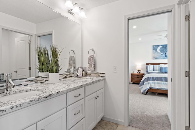 5315 Ranchview Ln N, Plymouth, MN 55446 - ensuite bathroom featuring double vanity, tasteful backsplash, and baseboards