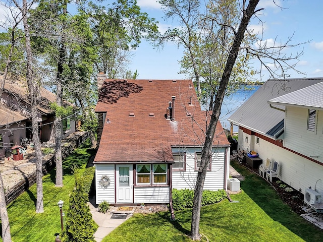 1379 7th Ave SE, Forest Lake, MN 55025 - rear view of property featuring a lawn, a shingled roof, central AC unit, and a chimney