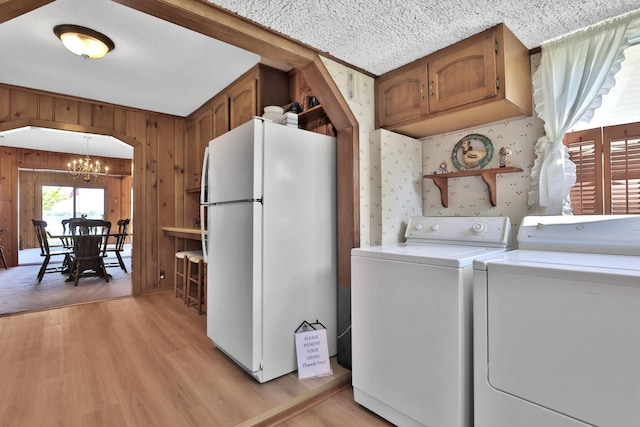 1379 7th Ave SE, Forest Lake, MN 55025 - washroom with a chandelier, light wood-style floors, wooden walls, independent washer and dryer, and a textured ceiling