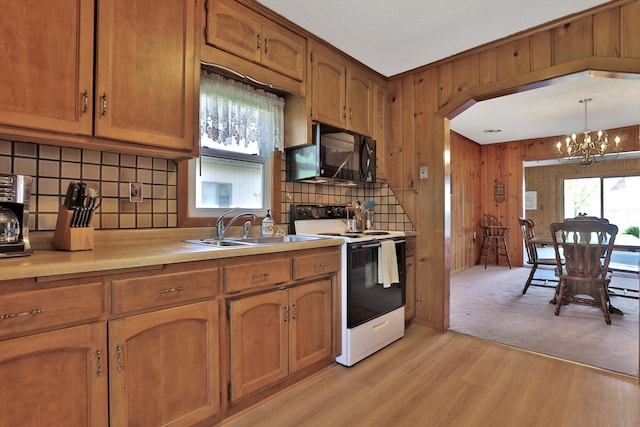 1379 7th Ave SE, Forest Lake, MN 55025 - kitchen featuring white range with electric stovetop, a sink, black microwave, decorative backsplash, and a chandelier