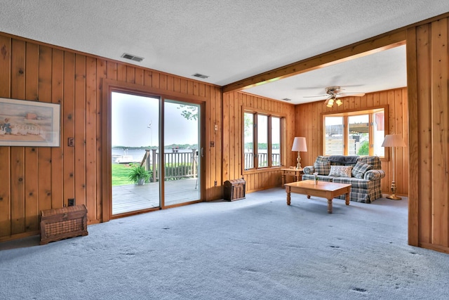 1379 7th Ave SE, Forest Lake, MN 55025 - living room featuring carpet flooring, wooden walls, a textured ceiling, and ceiling fan