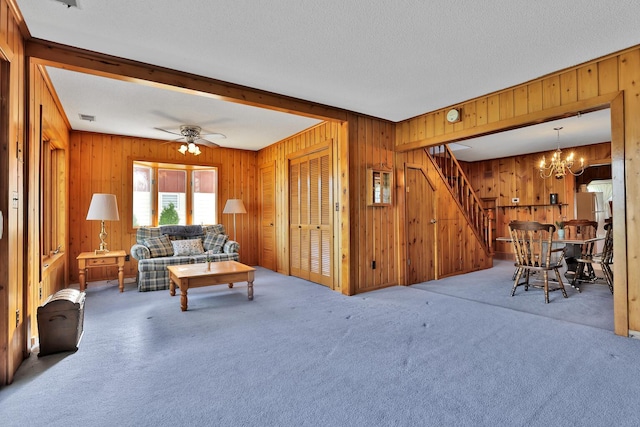 1379 7th Ave SE, Forest Lake, MN 55025 - living room featuring stairs, wood walls, carpet, a chandelier, and ceiling fan