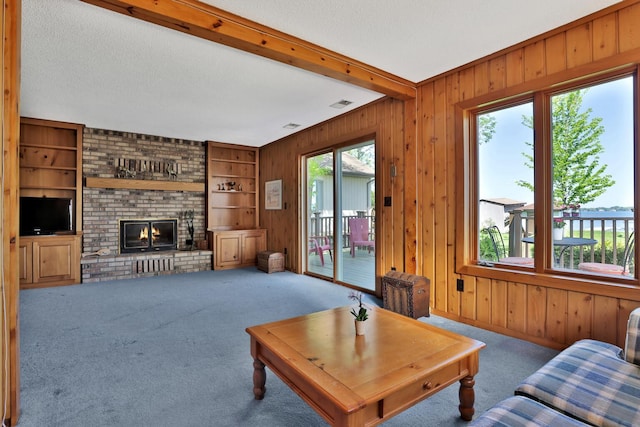 1379 7th Ave SE, Forest Lake, MN 55025 - carpeted living area with wood walls, a brick fireplace, beam ceiling, a textured ceiling, and built in features